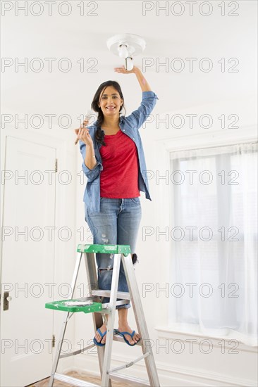 Mixed race woman painting room