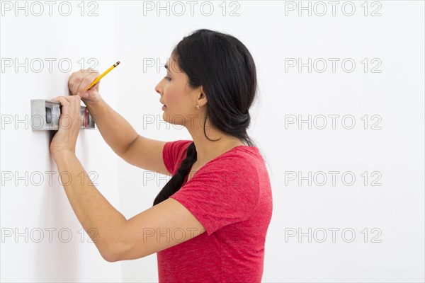 Mixed race woman using level