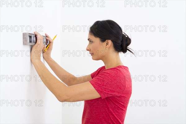 Mixed race woman using level