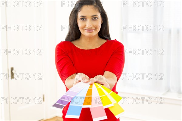 Mixed race woman holding paint swatches