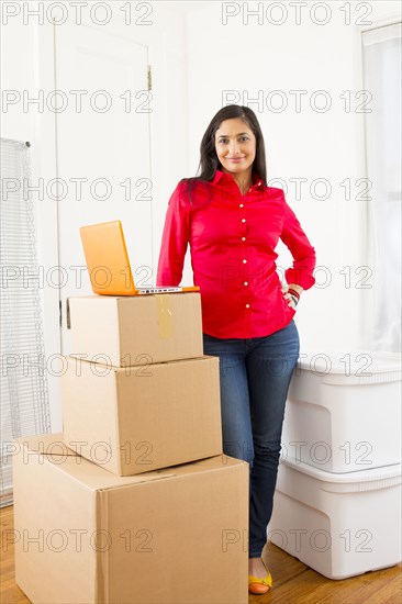 Mixed race woman with cardboard boxes in new home