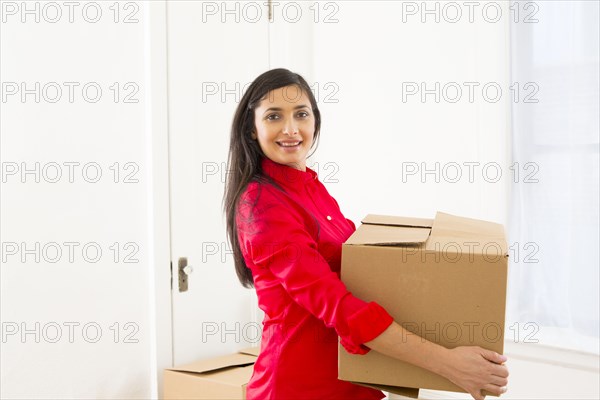 Mixed race woman carrying cardboard box
