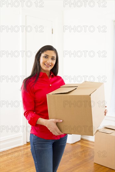 Mixed race woman carrying cardboard box