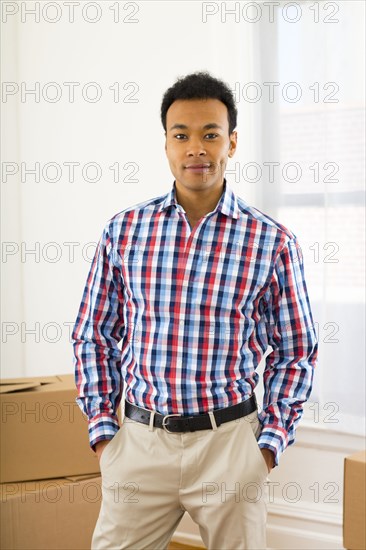 Mixed race man standing in new home