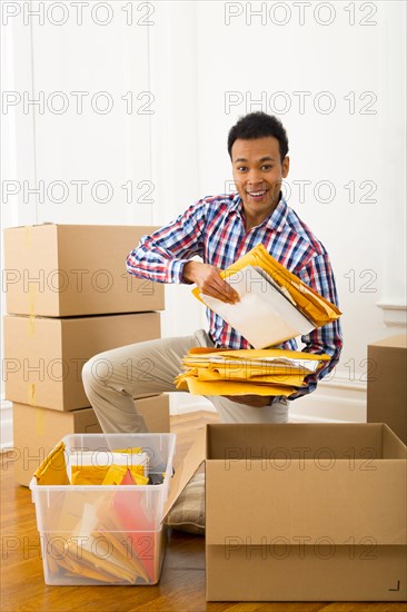 Mixed race man packing cardboard boxes