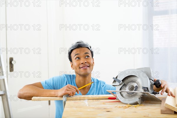 Mixed race carpenter marking wood