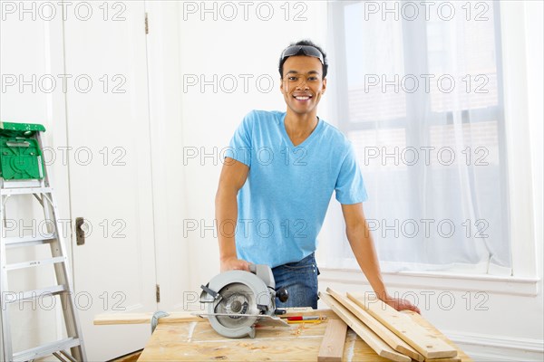 Mixed race carpenter with hand saw