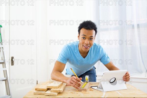 Mixed race carpenter working with digital tablet