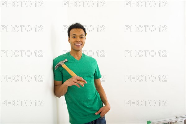 Mixed race man holding hammer