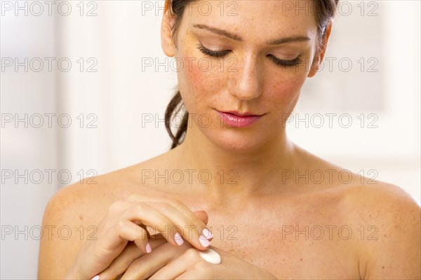 Caucasian woman applying lotion