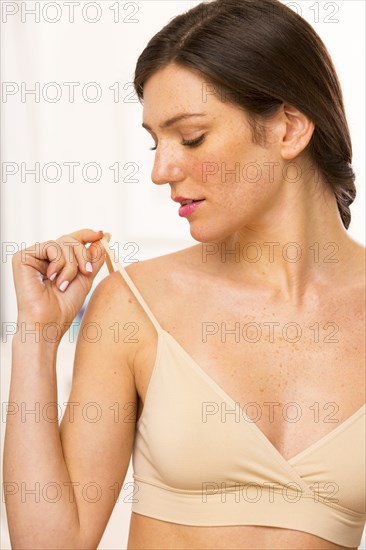 Caucasian woman checking bra straps