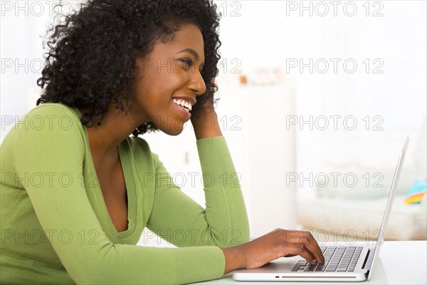 Mixed race woman using laptop at desk