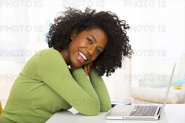Mixed race woman using laptop at desk