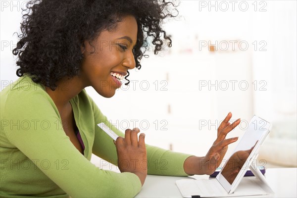 Mixed race woman using tablet computer at desk