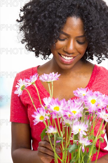 Mixed race woman holding bouquet of flowers