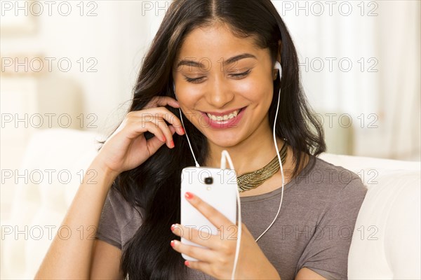 Hispanic woman listening to earphones