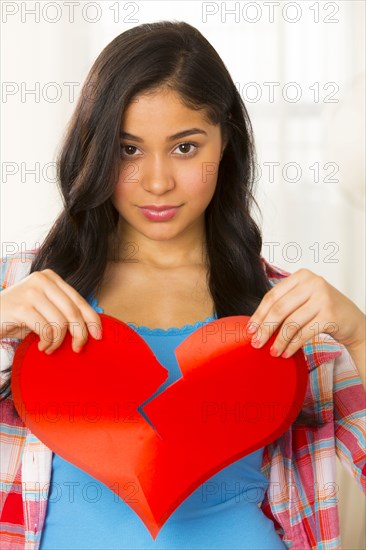 Hispanic woman holding broken heart