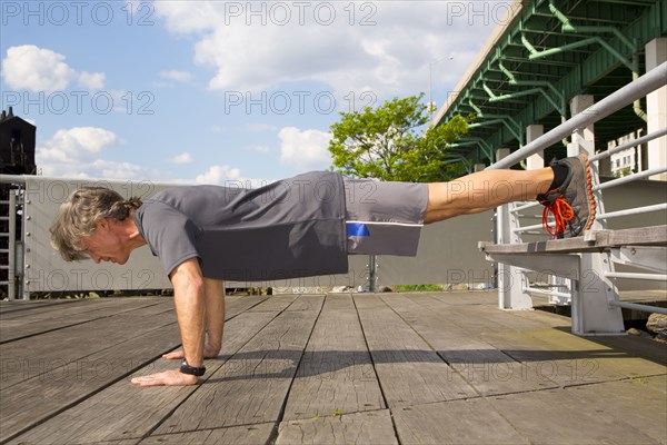 Caucasian man doing push ups on urban deck