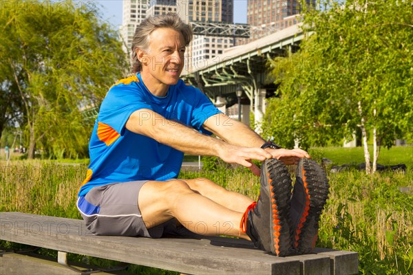 Caucasian man stretching in urban park