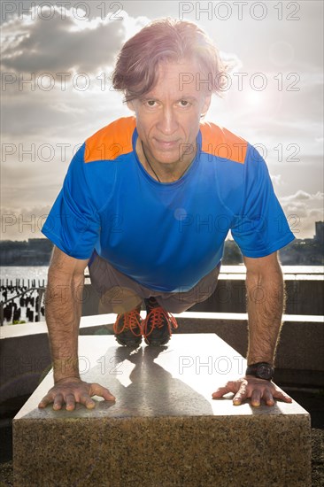 Caucasian man doing push ups in urban park