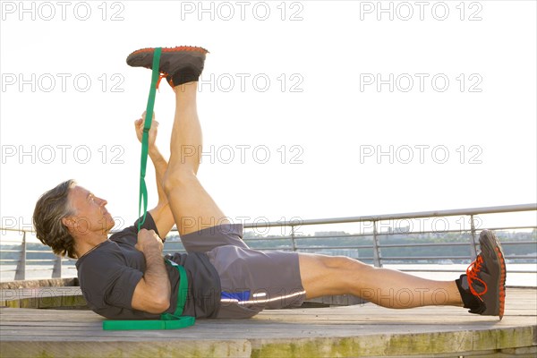 Caucasian man stretching in waterfront park