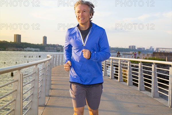 Caucasian man jogging on urban waterfront