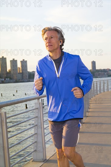 Caucasian man jogging on urban waterfront