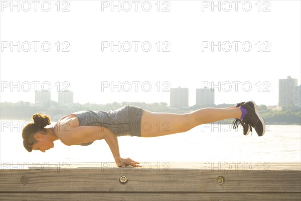 Mixed race woman exercising at urban waterfront