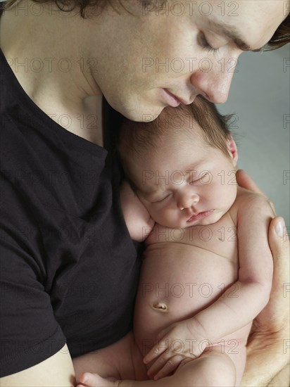 Father cuddling newborn baby