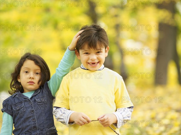 Hispanic brother and sister outdoors in autumn