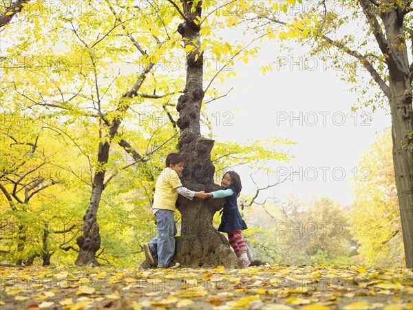 Hispanic brother and sister playing outdoors in autumn