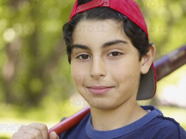 Mixed race boy holding baseball bat