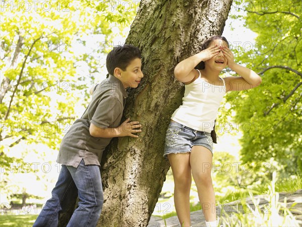 Mixed race brother and sister playing hide-and-seek