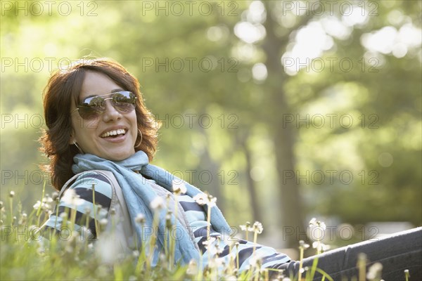 Smiling Hispanic woman laying in grass