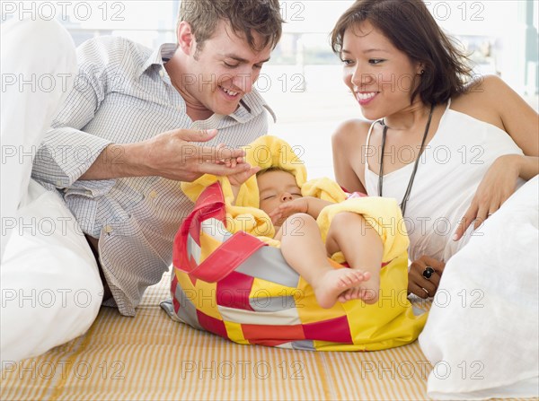 Proud parents looking at sleeping daughter