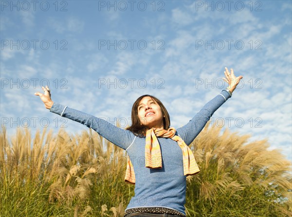 Mixed race woman with arms outstretched outdoors