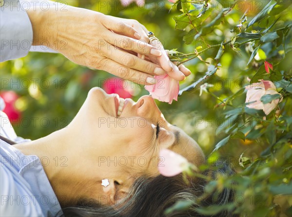 Caucasian woman smelling flower outdoors