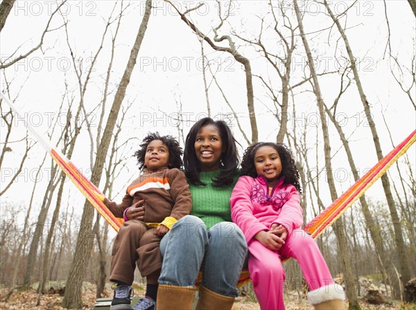 Mother and children sitting in hammock in autumn