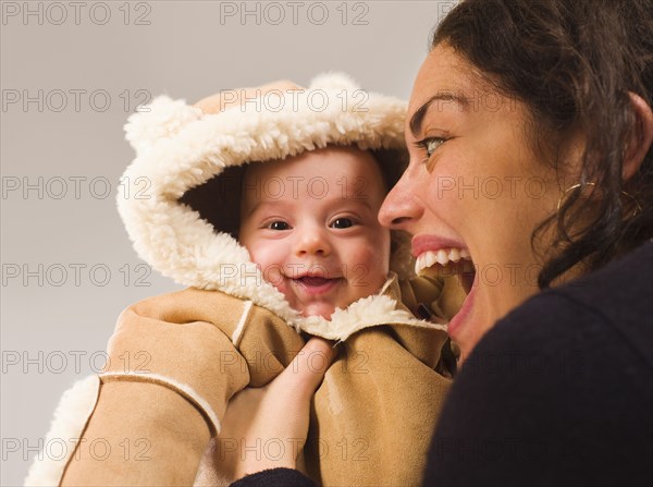 Mother holding newborn baby in winter coat