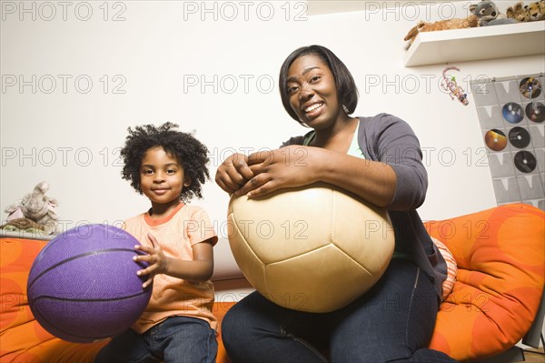 African American mother and son holding balls