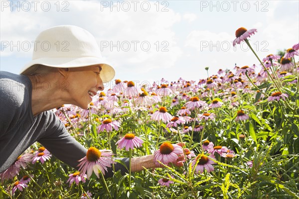 Smiling Caucasian woman looking at flowers