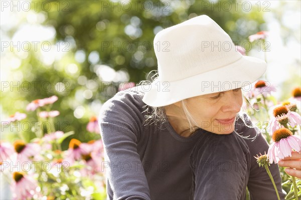 Caucasian woman examining flowers