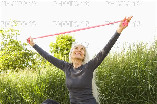 Smiling Caucasian woman stretching with resistance band