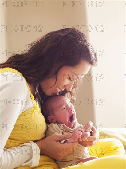 Mother holding newborn baby in her lap