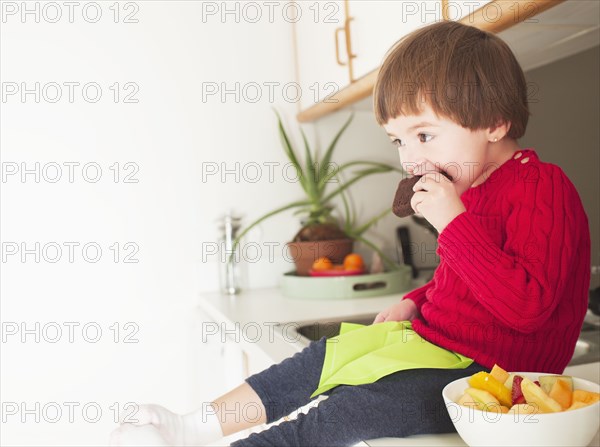 Mixed race boy eating brownie