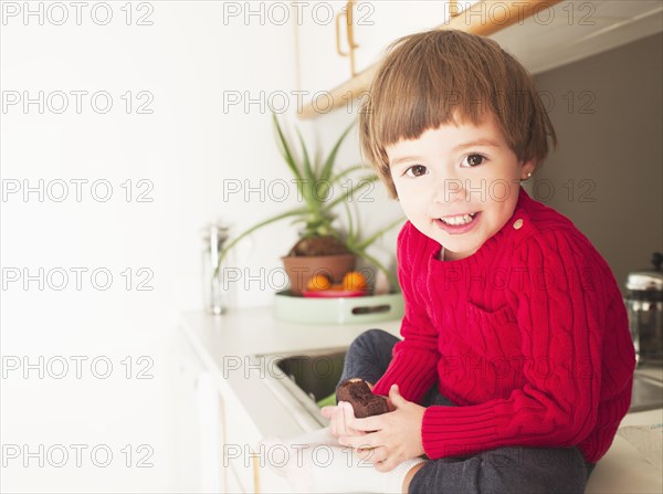 Mixed race boy eating brownie