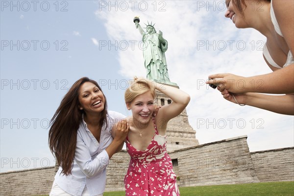 Laughing friends visiting the Statue of Liberty