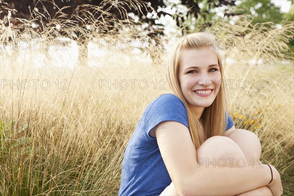 Caucasian teenager sitting in grass