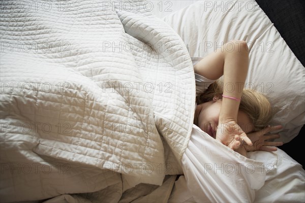 Caucasian teenage girl sleeping in bed