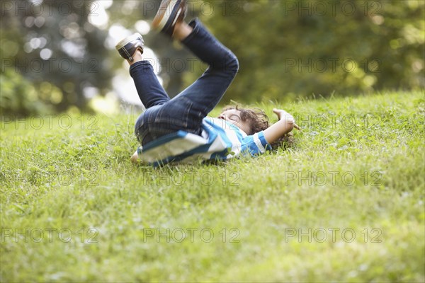 Mixed race boy playing in grass